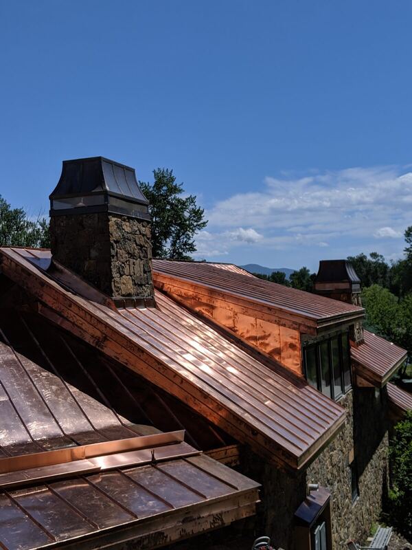 Copper standing-seam roof with stone chimney